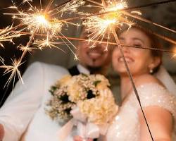 Imagine cu Couple holding sparklers at a wedding