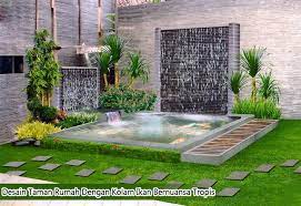 Jangan lupa untuk dekorasi taman belakang rumah yang mengelilingi kolam ikan minimalis ini dengan aksen alami seperti bebatuan hingga tanaman kecil yang sesuai. Desain Taman Rumah Dengan Kolam Ikan Bernuansa Tropis Kumpulan Cara Praktis