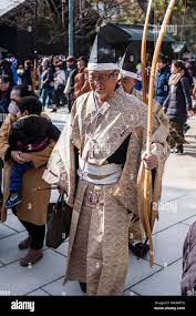 Japan, Nishinomiya Shinto Shrine, New year. Elderly Male archer dressed in  Heian period style, walking through the shrine grounds after a new year  archery contest, common for New Year and other festive