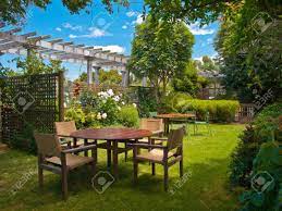 Wooden garden furniture will need to be treated at least once a year to ensure the wood is kept at its best. A Wooden Dining Table Set In Lush Garden Setting Stock Photo Picture And Royalty Free Image Image 10834437