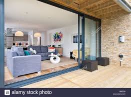 Telecharger Cette Image Un Plan Ouvert Salon Salle A Manger Et Cuisine Avec De Grandes Portes Coulissantes En Ve Porte Coulissante Porte Salon Terrasse Bois