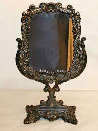 The frame is made of ornately wrought brass. Ornate Victorian Mirror On Pedestal Painted Black W Gold Highlights C Early 20th Century