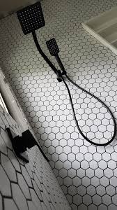 If you want to use bold colors in your bathroom, use large neutral tiles with narrow grout lines that won't distract from the focal point. White Hexagonal Tile Black Grout Black White Bathroom Black Showers Black Grout White Hexagon Tiles Black Bathroom Taps