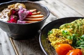 There is a pretty common saying that goes breakfast is the most important meal of the day. while all meals are essential, that saying is true to some extent. Top View Food Photo Of Healthy Breakfast Porridge With Fresh Fruits And Peanut Butter And A Healthy Vegan Lunch With Black Beans Avocado Baked Potatoes And Cherry Tomatoes On A Wooden Table