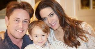 Fernanda Machado faz yoga na praia com o filho