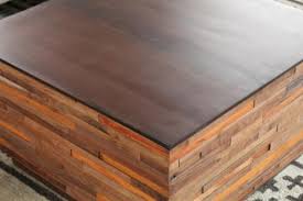 A distinctive coffee table in a rectangular shape made from reclaimed floorboards in a victorian style. Recycled Wood Block Square Coffee Table To Rent As Prop