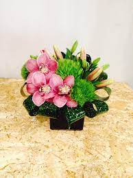 Beautiful Pink Orchids Lilies And Hydrangeas Perfectly Arranged In A Container With Ornamental Folia Orchid Flower Arrangements Flower Delivery Flower Service