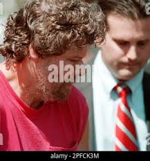 James Gillin, left, charged in the 1992 murder of his 25-year-old mentally  retarded adopted daughter, is shown in this Aug. 8, 1999 photo being taken  into custody in Bull Skin Township, Pa.,