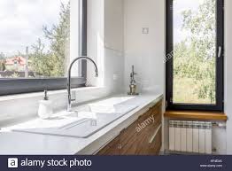 Moderne, puristische küche in weiß: Moderne Kuche Mit Weisser Arbeitsplatte Spule Und Grosse Fenster Stockfotografie Alamy