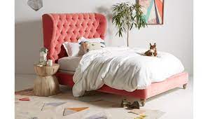 The design features a fully upholstered headboard, footboard and side rails, with elegant, tapered solid wood legs. Tufted Wingback Bed Anthropologie