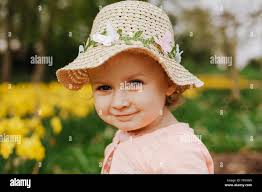 cute blonde little girl smiling with yellow daffodils in the spring country  Stock Photo