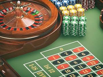 Gambling or casino background concept casino roulette wheel with casino  chips on green table | Premium Photo
