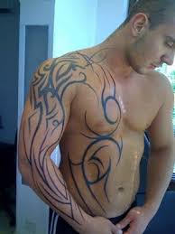 This chest tattoo shows a bird holding onto a black rosary bead. Chest Tattoos For Men
