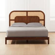 The headboard is made of woven cane and has floating side tables with black glass removable. Nadi Cane Bed Cb2