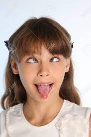 白いブラウスを着た美少女のクローズアップ肖像画。かわいい魅力的な子供は、彼女のピンクの舌を引っ張り、彼女の目を転がすことによっていじめます。その若い 女子高生は9歳です。の写真素材・画像素材 Image 99943276