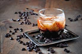 Foto Stock Kahlua liqueur with cream in glasses with coffee beans on a  wooden background, selective focus | Adobe Stock