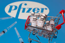 A syringe are seen in front of the pfizer logo in. Pfizer Biontech S Vaccine What You Need To Know In 500 Words Coronavirus Pandemic News Al Jazeera