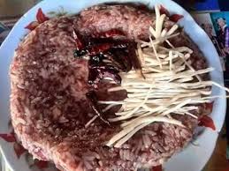 景栋傣族小吃叫烤送，翻釋叫酸饭，其实不酸是用猪血和米饭和其他调味料拌后用芭蕉叶包扎后蒸的。