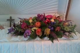 Roses, tulips, lilies, daisies, irises, orchids, poms Garden Of Glory Inside Casket Spray In Murrysville Pa Rosebud Floral Giftware