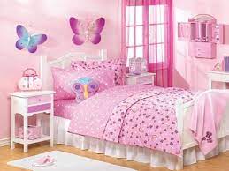 Pink and purple girls' bedroom boasts pink patterned headboards with matching pleated bedskirts on twin beds dressed in white and purple bedding as well as a blood red faux fur throw blankets flanking a white lacquered nightstand and blush pink double gourd lamp. Pin On House