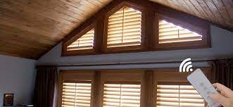 A brass sconce illuminates a window nook boasting a window dressed in white roman shade hung beneath a shiplap vaulted ceiling complementing shiplap walls. How To Shade Your Enormous Cathedral Windows Zebrablinds