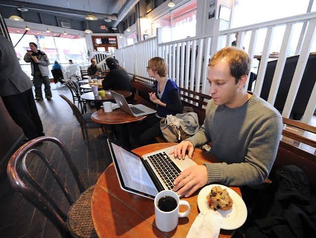 People working from a laptop-friendly cafe