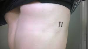 Roman numerals with tribal design tattoo on right shoulder. Side Tattoo Of The Number Four In Roman Numerals