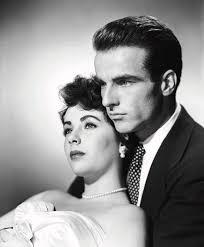 Elizabeth Taylor and Montgomery Clift in 'A Place in the Sun' (1951).  Costume designer Edith Head won one of her eight Academy Awards for costume  design by designing the prom-style ball gown