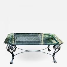 There is a brass colored ornamentation on the corner of each leg. Modern Chippendale Style Wrought Iron Coffee Table W Glass Top