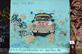Des graffeurs recouvrent et détournent les croix gammées sur les murs de berlin. East Side Gallery A Berlin