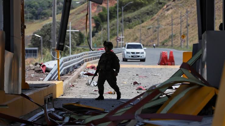 Emergency services and law enforcement personnel responding to the scene of a car bomb explosion in Colombia.