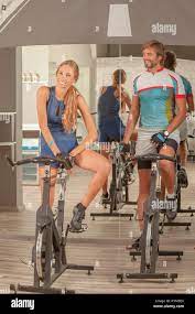 Young beautiful female and male having fun in a cycling gym teasing each  other Stock Photo - Alamy