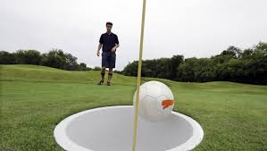 A Player On A Soccer Golf Course Watches Their Shot Near The Hole, Showing The Scale Of The Game