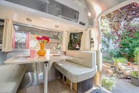 An angled double sink at the kitchen area with a refrigerator and a three burner. Decorating Ideas For Your Airstream Rv Trailer And More Hgtv S Decorating Design Blog Hgtv