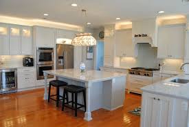 Off White Cabinets With Light Blue Island Staggered Cabinets With Glass Accents Quartzite Count In 2020 Off White Cabinets Quartzite Countertops Staggered Cabinets