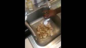 seasoning chicken in the sink with jay