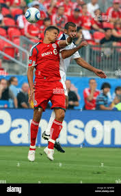 Toronto FC defender Adrian Cann (12) and Los Angeles Galaxy midfielder  Jovan Kirovski (9) in collide in mid air as they battle for control of the  ball at BMO Field in Toronto,