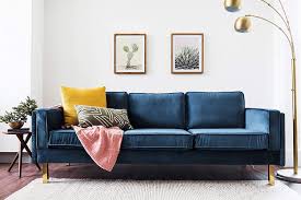 The back, track arms, and frame are made from solid and manufactured wood in a warm wood. Blue Velvet Sofas With Creative Living Room Decor Ideas