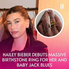 Hailey Bieber recently showcased a new piece of jewelry dedicated to her  son, Jack Blues. The ring features two prominent birthstones: a  square-shaped peridot representing Jack's August birth and a pear-shaped  topaz
