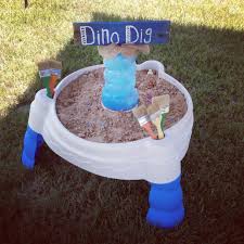 Dino Party Dino Dig Dino S Buried In Sand In A Water Play Table Cheap Paint Brushes Spray Painted To Match The Party Colors Kids Party