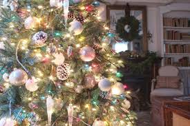 Hang garland and lights on the tree before adding ornaments. How To Decorate With White Vs Multi Colored Christmas Lights