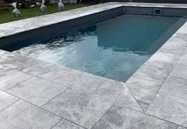 Silver travertine pool copings feature soft grays, cool whites, and hints of a blue undertone. Tundra Grey Sandblasted Pool Coping