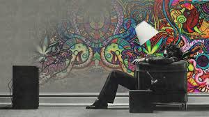 Hipwallpaper is considered to be one of the most powerful curated wallpaper community online. Man Is Sitting On Sofa In Colorful Painting Background Hd Trippy Wallpapers Hd Wallpapers Id 46909