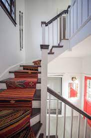Mexican tile stair inlays, bold art and vibrant colors are truly eye candy . Winding Staircase With Dark Wood Steps And Matching Railing And Bold Colorful Southwestern Runner Hgtv