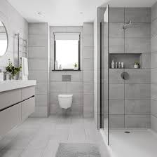 Gray penny border bath floor tiles in a lovely white and airy bathroom designed with white penny floors, white subway wall tiles, and small a white dual washstand. 25 Latest Bathroom Tiles Designs With Pictures In 2021