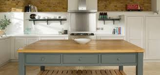 The bespoke kitchen cabinetry is sophisticated in a pale shade of grey with complimentary chrome handles and a grey tiled splashback. The Thatched Cottage Suffolk Modern Soft Grey Country Cottage Kitchen Homify
