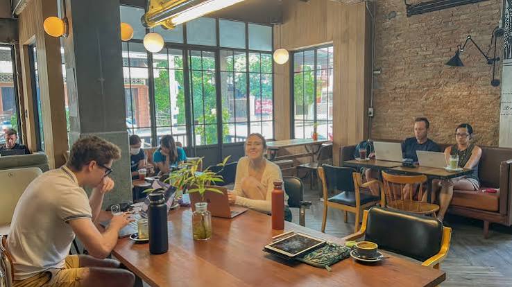 People working from a laptop-friendly cafe
