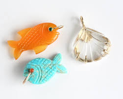 All the best colors and gemstones hanging out together. Here is our Fish  Charm in turquoise & also in Carnelian paired with our Marie Shell Charm in  Clear Rock Crystal.