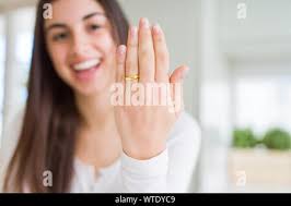 Beautiful young woman showing hand wearing wedding alliance ring Stock  Photo