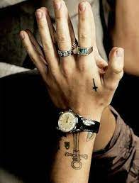 A small cross tattoo on harry's left hand between his thumb and index finger 44. Harry Styles H S Harry Styles Hands Harry Styles Tattoos Harry Styles Pictures